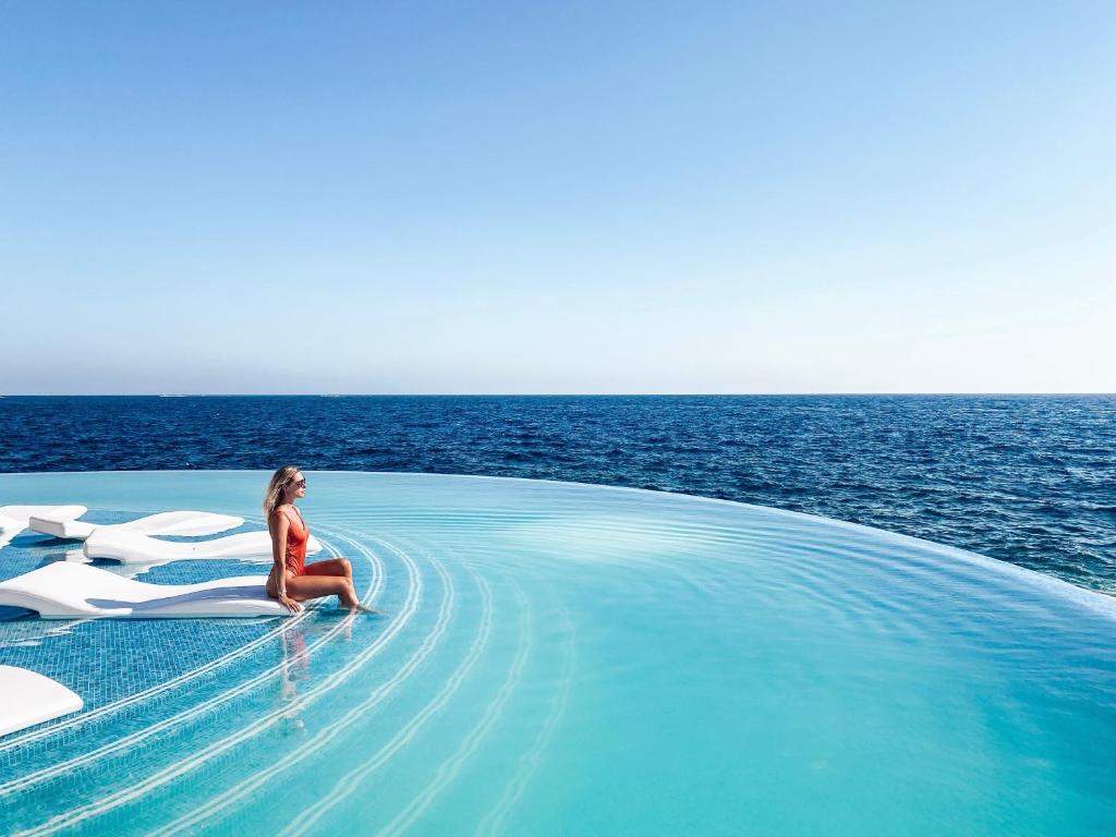 a woman sitting in a infinity pool on a boat in the ocean at 1926 Le Soleil Hotel & Spa in Sliema