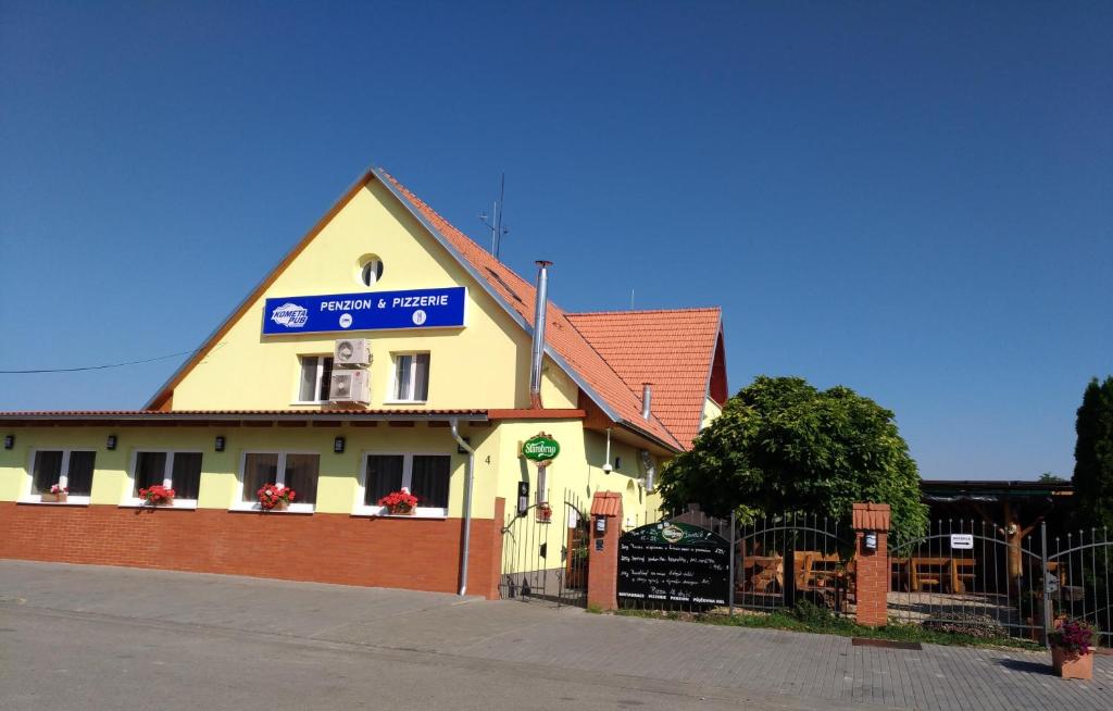 ein Gebäude mit einem Schild an der Seite in der Unterkunft Penzion Kometa in Pasohlávky