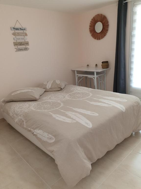 uma cama com um edredão branco num quarto em Le Clos Varnay Jardin em Meusnes