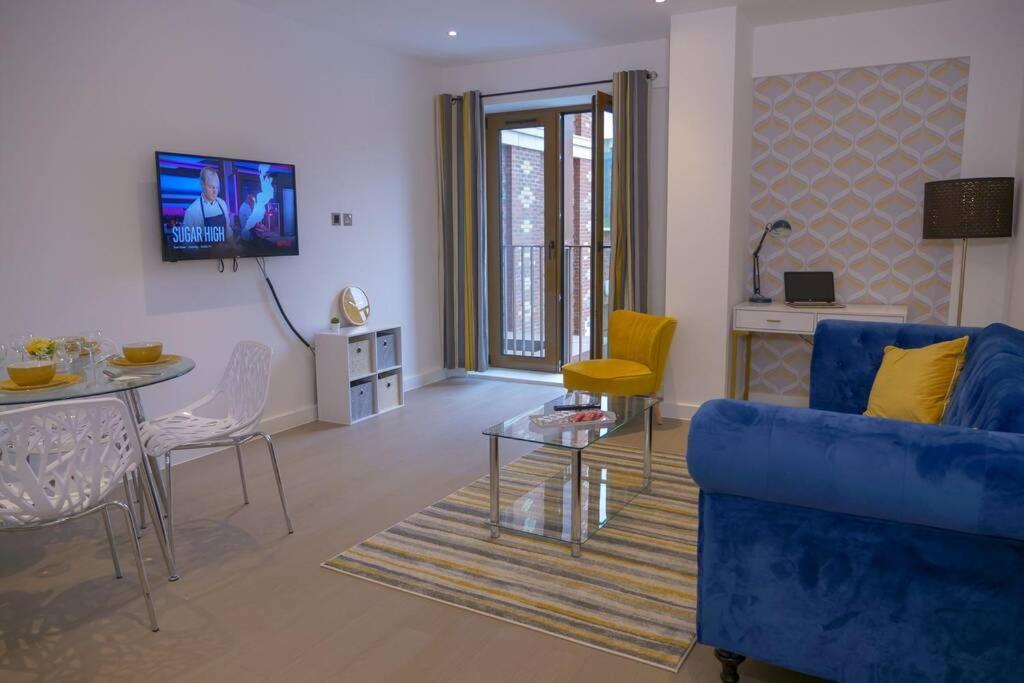 a living room with a blue couch and a table at Maplewood properties - St Albans one bedroom luxurious flat in Saint Albans