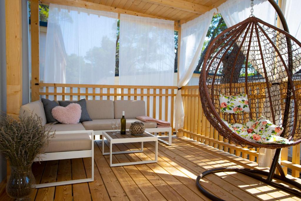 a porch with a couch and a swing at Mobile Home Baško Polje TBMrent in Baška Voda