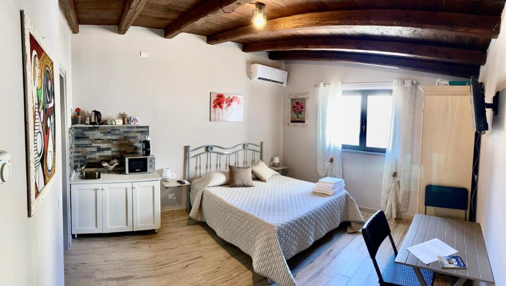 Un dormitorio con una cama y una mesa. en LA PICCOLA DEPENDANCE, en Tuscania