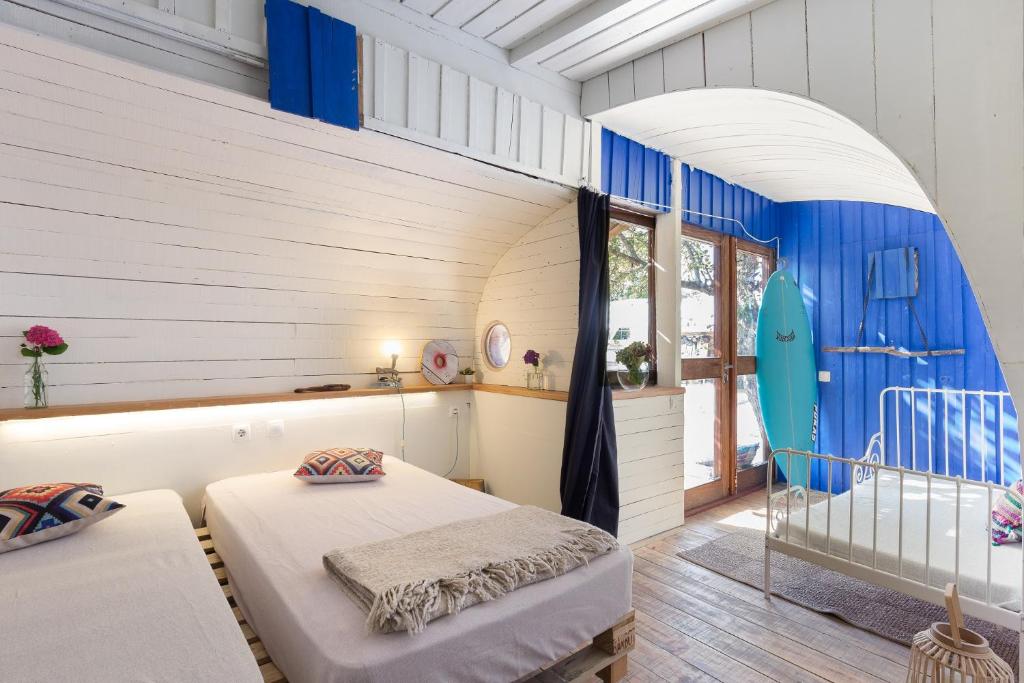 a room with two beds in a room with a window at Maceda Surf Camp in Maceda