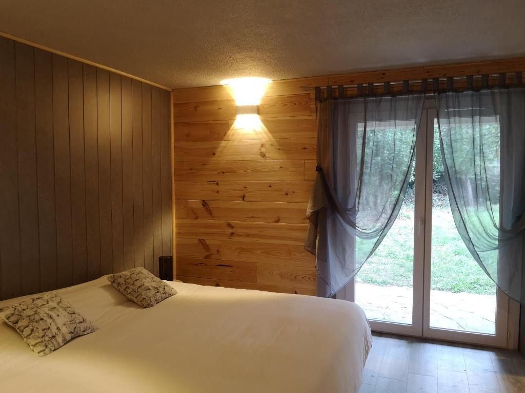a bedroom with a white bed and a window at L'Imprévu in Bourisp