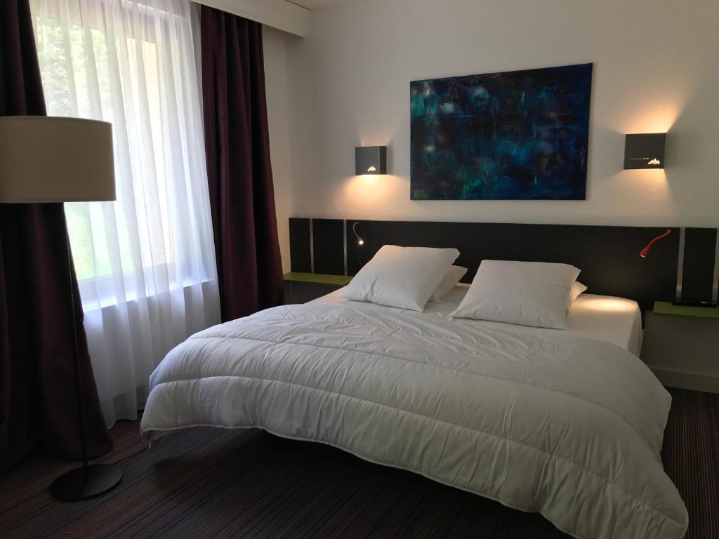 1 dormitorio con 1 cama grande con sábanas blancas en La maison de Cécile, en Ventron