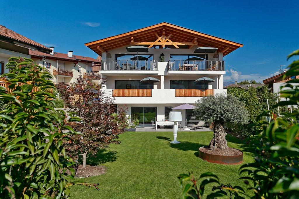 a large building with a balcony and a yard at vinum - schlosserhaus 31 in Tesimo
