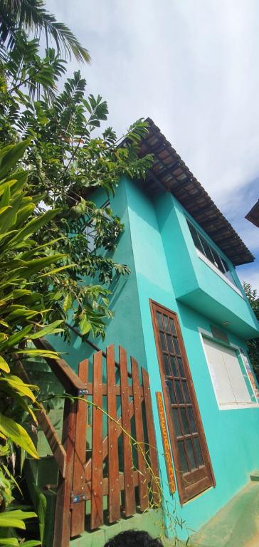 ein blaues Haus mit einem Fenster und einem Zaun in der Unterkunft Flat do Léo in Praia de Araçatiba