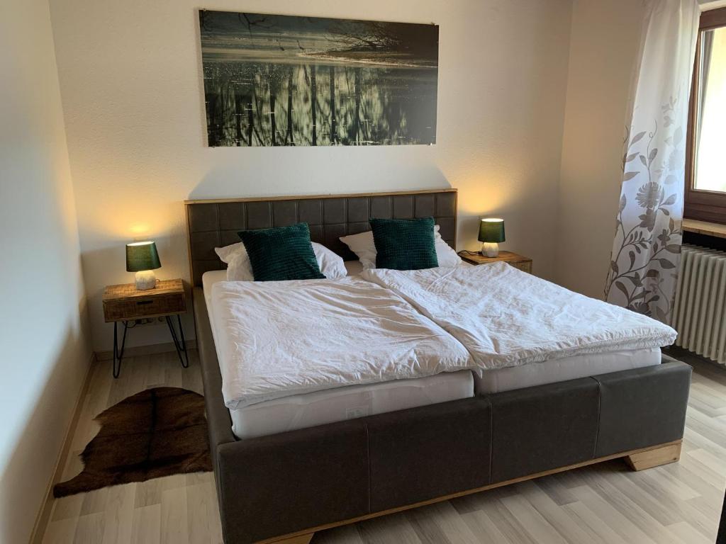 a bed in a bedroom with two lamps on tables at Schlossblickwohnung Schiel in Gernsbach