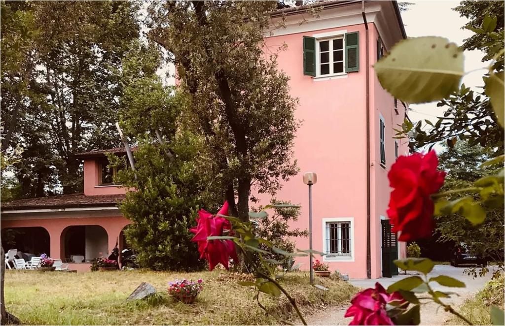 een roze huis met rode bloemen ervoor bij I POGGI DI S.CATERINA in Sarzana