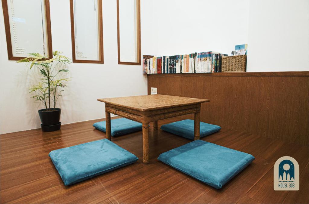 a wooden table with blue cushions in a room at House 303 小阿姨的家民宿 in Hualien City