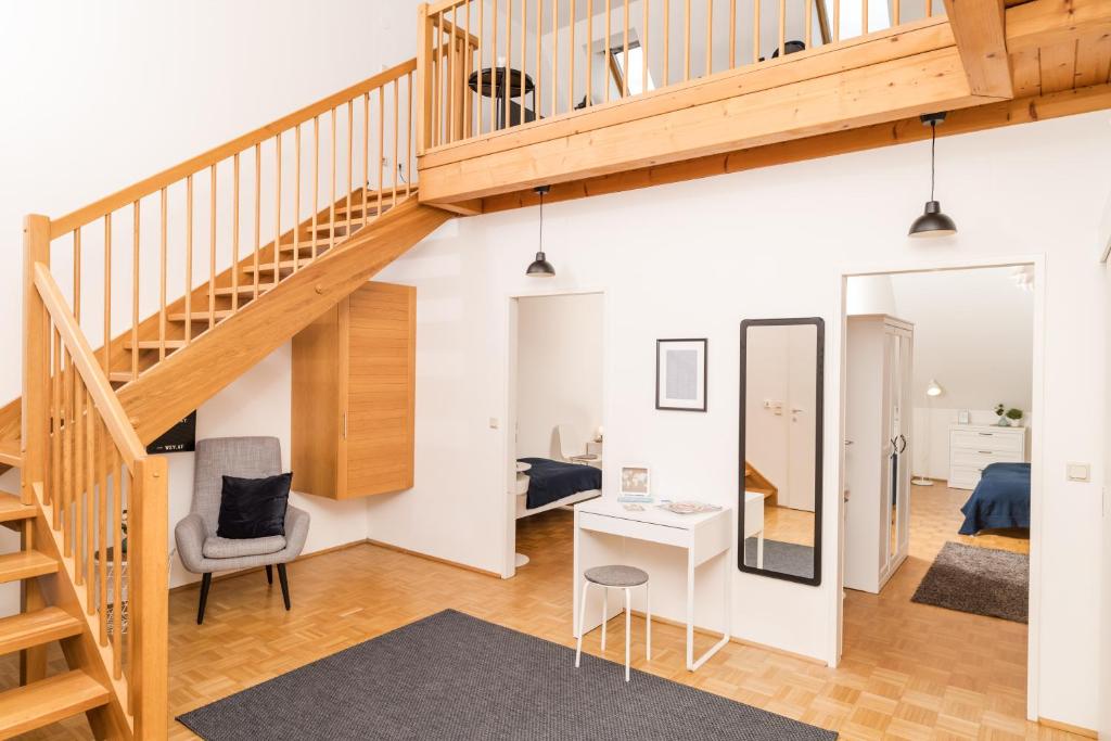 a room with a staircase and a living room with a desk at Cozy Kunsthaus GRAZ in Graz