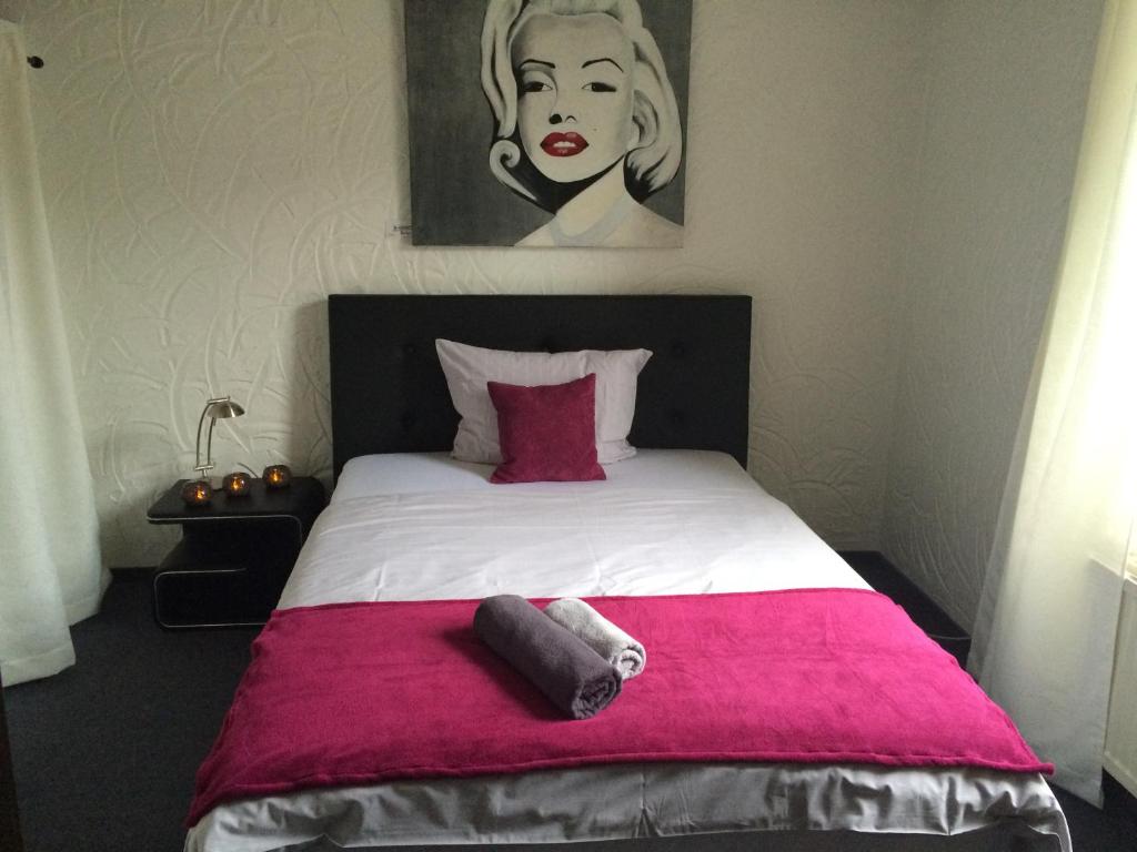 a bedroom with a large bed with a pink blanket at Haus Gerry in Düsseldorf