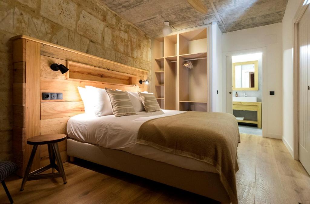 um quarto com uma cama grande e uma parede de pedra em ERASMUS PLAZA em Salamanca