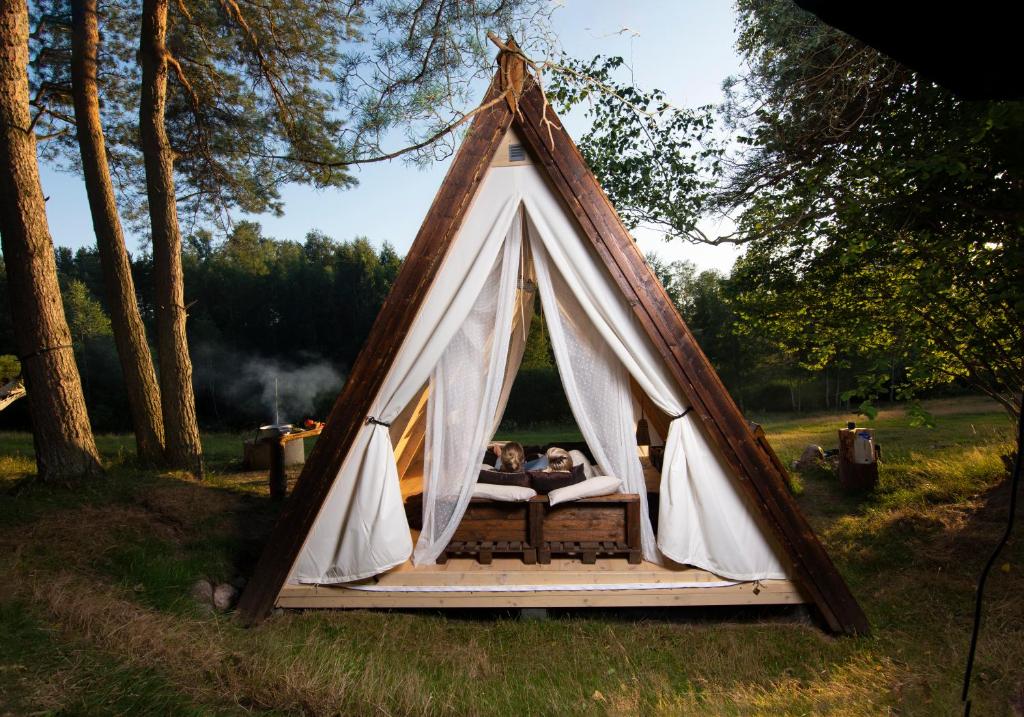 un grupo de personas sentadas en una tienda tipi en Sandfallet Glamping, en Laholm