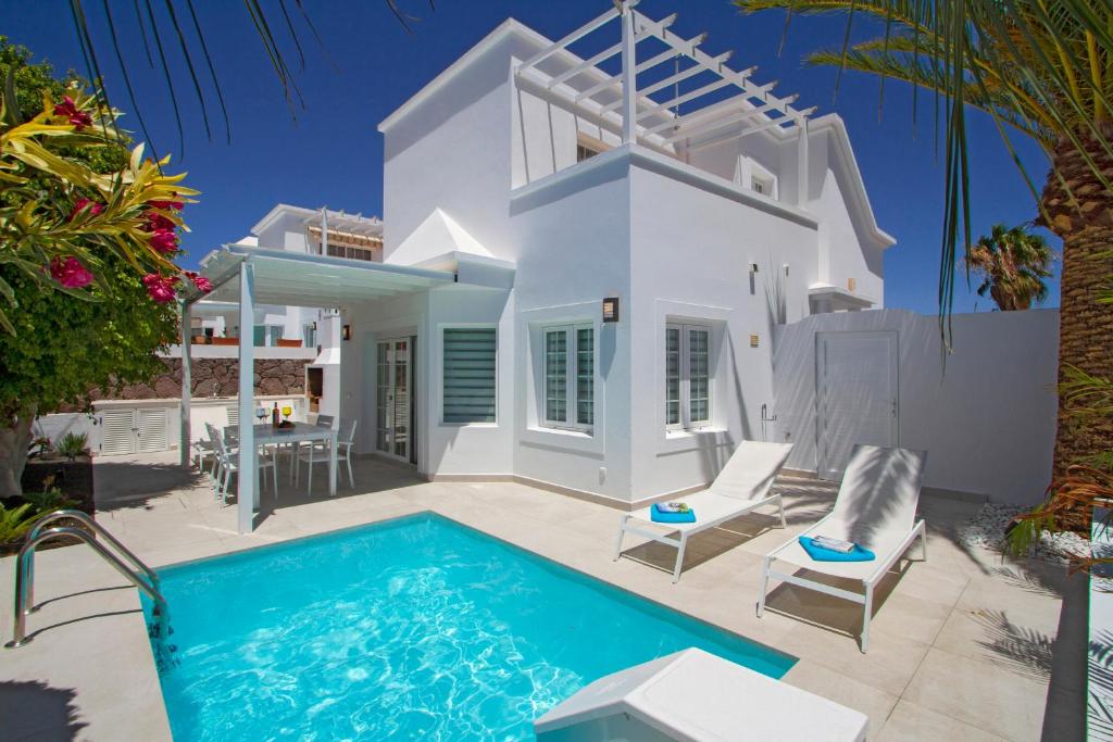 een villa met een zwembad voor een huis bij VILLA CHARLANA by Buenavilla in Puerto del Carmen