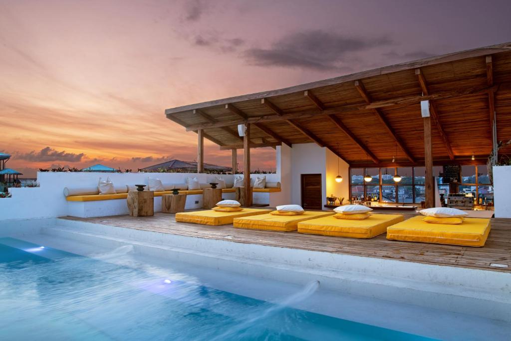 a villa with a swimming pool at sunset at Upendo House Hotel Zanzibar in Zanzibar City