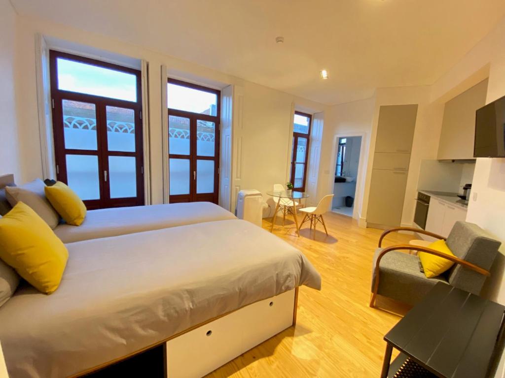 um quarto com uma cama grande e almofadas amarelas em Porto.Leça - Studios and Apts (Apt D) em Leça da Palmeira