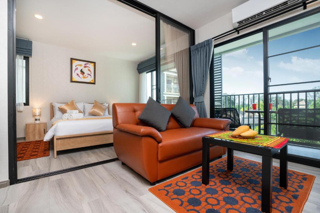 - un salon avec un canapé et un lit dans l'établissement The Apartment at The Title Residencies Naiyang Beach, à Phuket