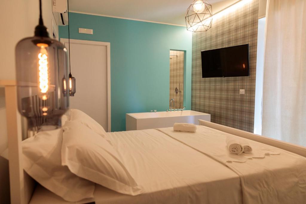 1 dormitorio con 1 cama y baño con TV. en B&B LA CUPOLA en Catania