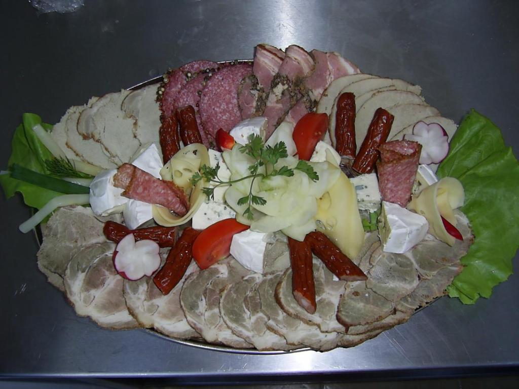 a plate of food with meat and vegetables on it at Pensjonat KoGa in Kołobrzeg