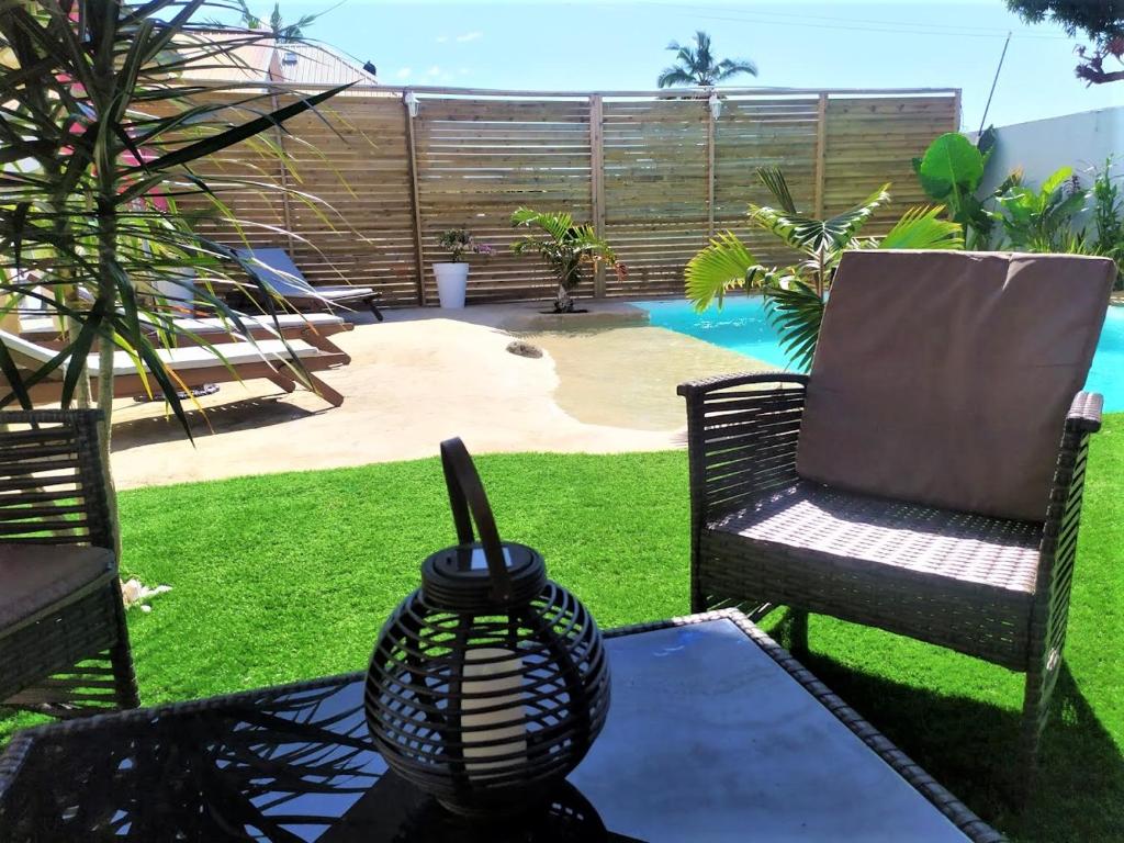 une terrasse avec une table, des chaises et une piscine dans l'établissement Fleur de passion, à Saint-André