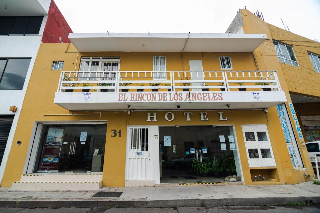 um edifício amarelo com um hotel com varanda em El Rincon de Los Angeles em Colima