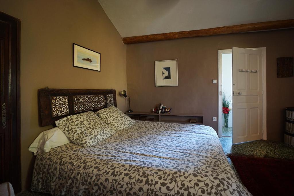 1 dormitorio con 1 cama grande con colcha blanca en Maison du Loup, en Ganges