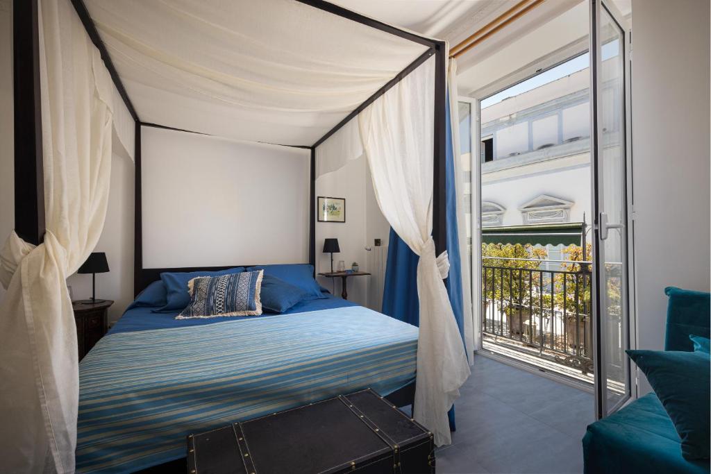 a bedroom with a canopy bed and a balcony at Case Barbera Vetriera in Palermo
