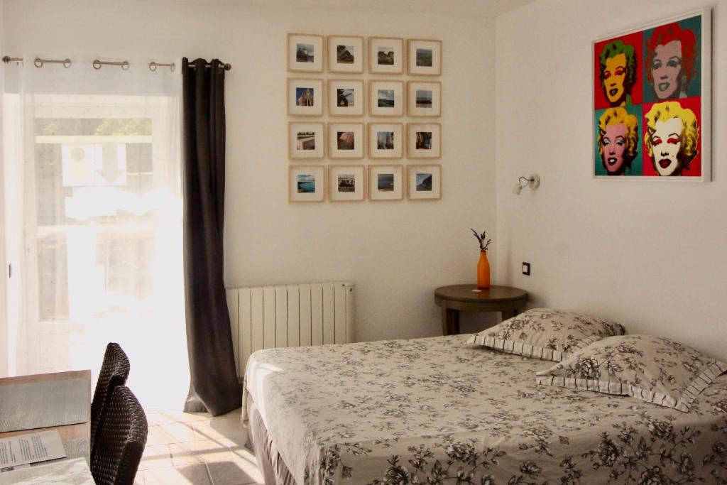 1 dormitorio con 1 cama y algunas fotos en la pared en Chambre Pomme Cannelle Premium Aux portes de Bayeux Normandie 2 pers, en Monceaux-en-Bessin