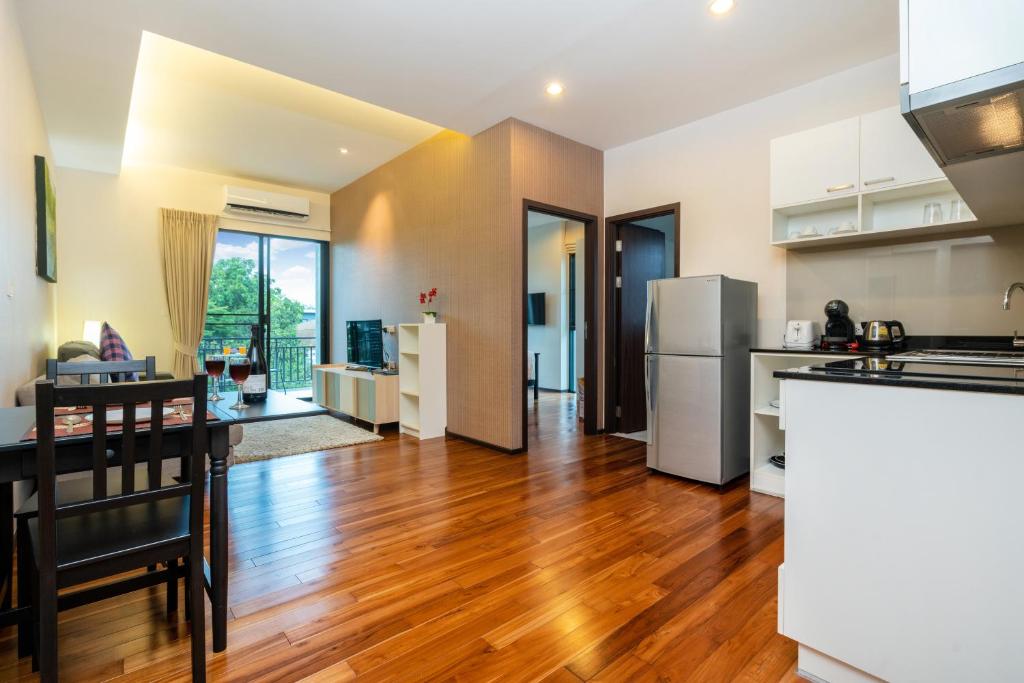 an open kitchen and living room with a wooden floor at The Title Rawai Beach West Wing in Phuket Town