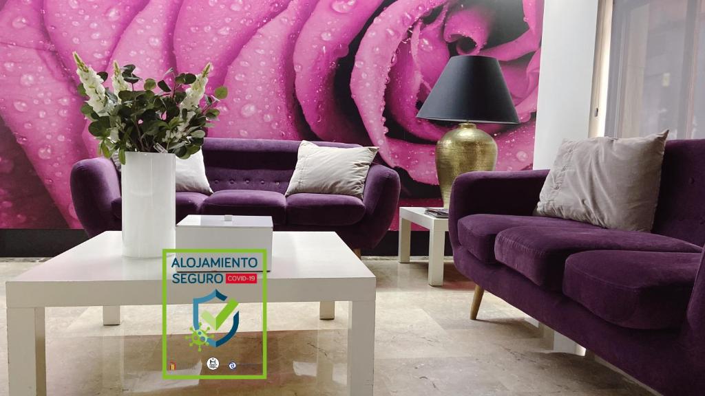 un soggiorno con divani viola e parete viola di Hotel Rio Arga a Saragozza