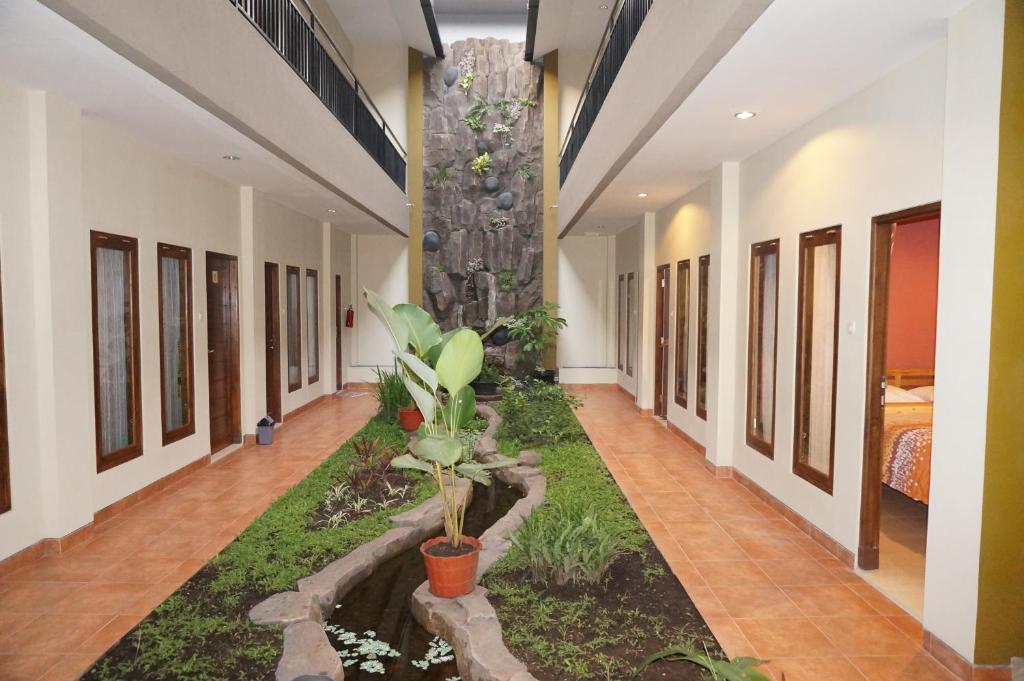a hallway with a garden in the middle of a building at Aloha Hotel Yogyakarta in Yogyakarta