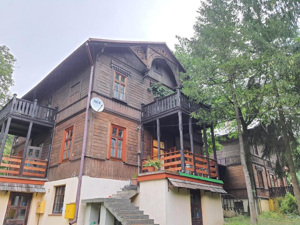 una gran casa de madera con balcones y un árbol en Willa Widok en Nałęczów