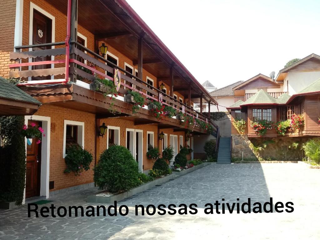 a building with a balcony with plants on it at Pousada Saint Gallen in Campos do Jordão