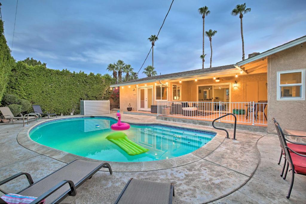 a swimming pool with chaise lounge chairs and a house at Palm Desert Abode Pool, Walk to El Paseo District in Palm Desert