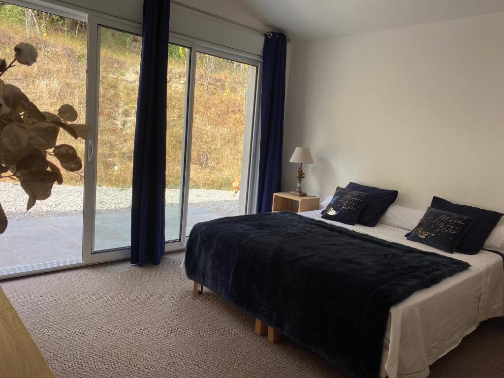 a bedroom with a bed and a large window at Une chambre au Haras in Céreste