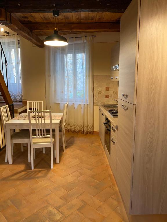 ピティリアーノにあるLe Casette nel Borgoのキッチン(白いテーブル、テーブル、椅子付)