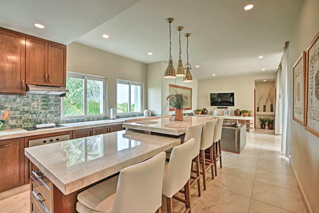 a kitchen with a large island with white chairs at Ocean-View Oasis on Playa Norte with Resort Amenities in Isla Mujeres