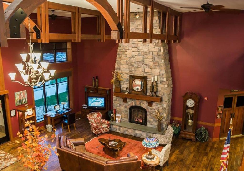 a living room with a stone fireplace and a couch at Timberlake Lodge in Grand Rapids