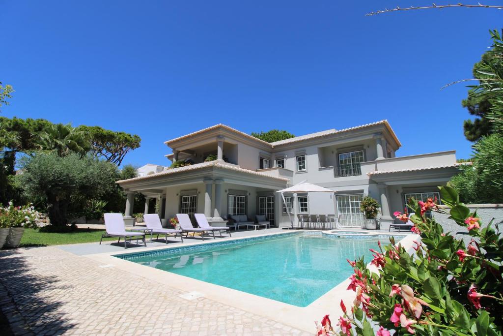 a house with a swimming pool in front of it at Charming Exceptional Golf Villa in Algarve in Faro