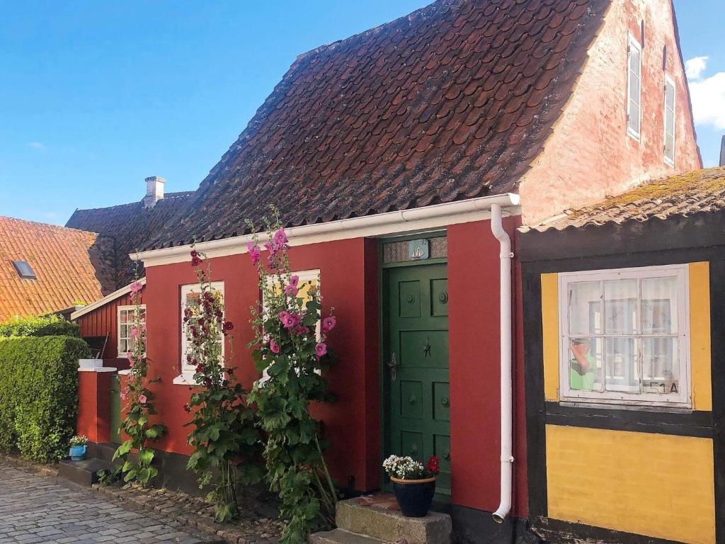 エーロスケービンにあるHoliday Home Nørregadeの緑の扉と花の赤い家