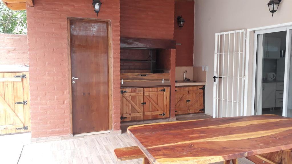 una cucina con armadi in legno e tavolo in legno di Hermosa Casita Paso Patria a Paso de la Patria