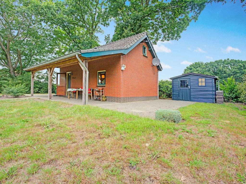 ein kleines rotes Backsteinhaus mit einem blauen Schuppen in der Unterkunft Holiday cottage in Schijf with a fenced garden in Schijf