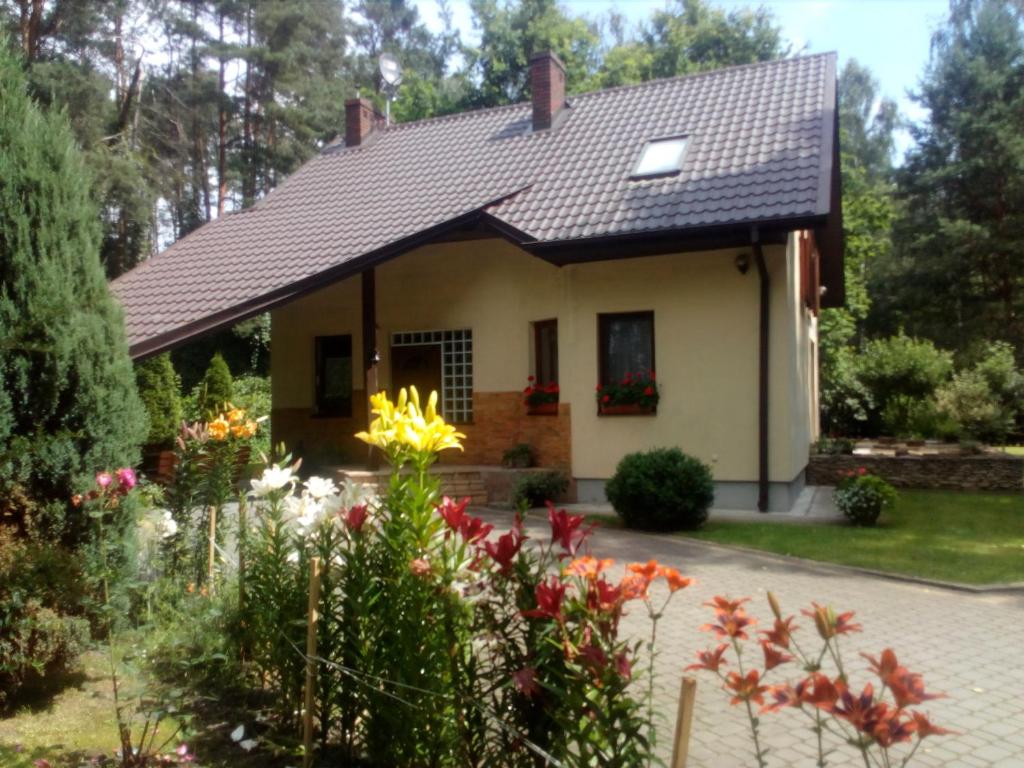 una casa con un jardín delante de ella en Noclegi Po Rosie en Busko-Zdrój
