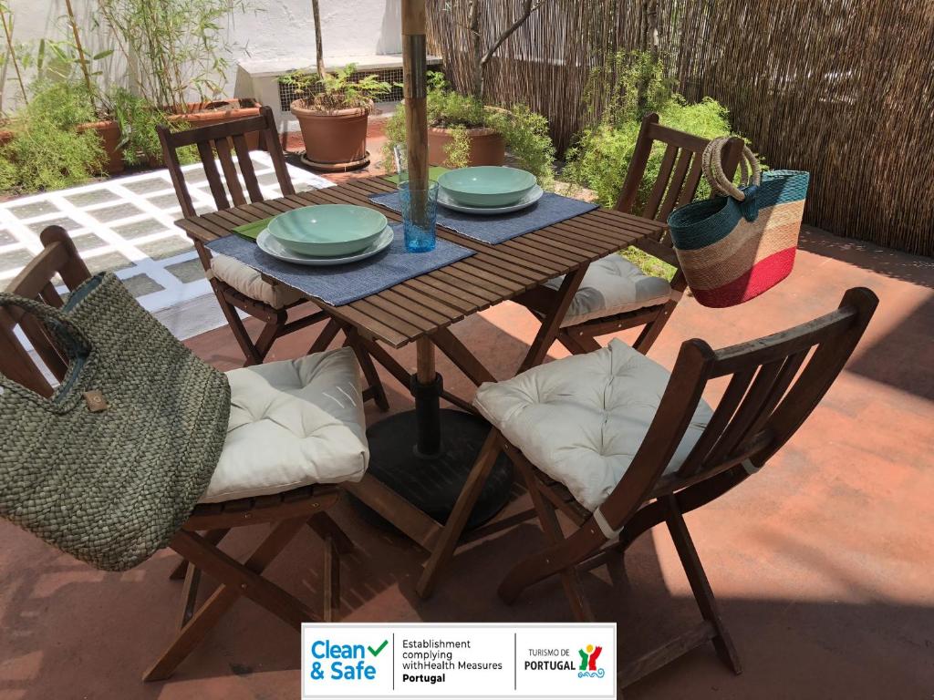 un tavolo e sedie in legno su un patio di Arroios BnB a Lisbona