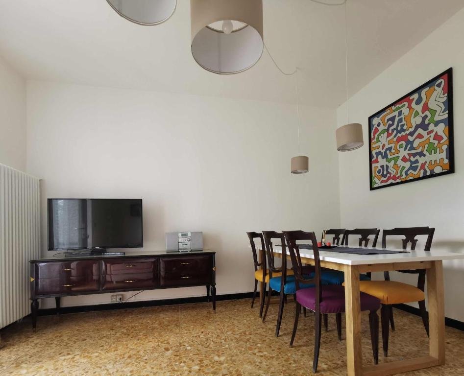 a dining room with a table and chairs and a tv at La casa gentile appartamento Aurora in Roccaverano