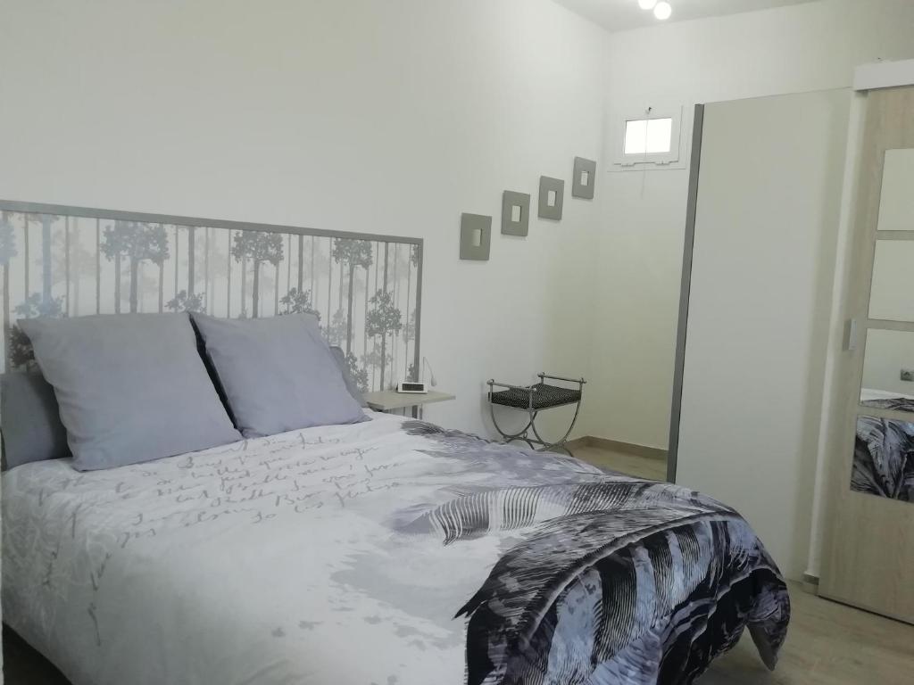 um quarto com uma cama grande e almofadas azuis em La Casita del Naranjo em Agüimes