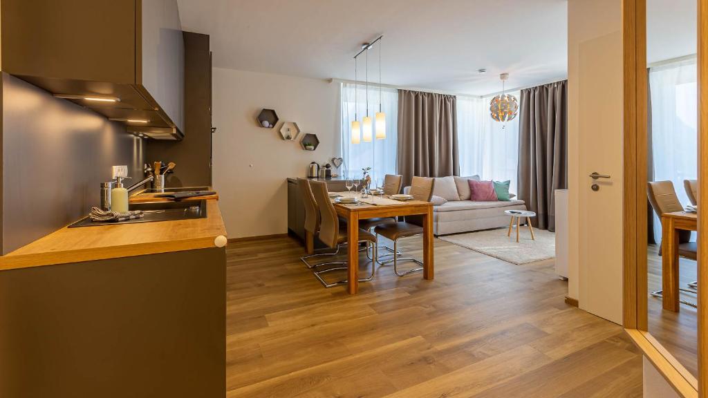 eine Küche und ein Wohnzimmer mit einem Tisch und einem Wohnzimmer in der Unterkunft Grimming Lodge Arnika in Tauplitz