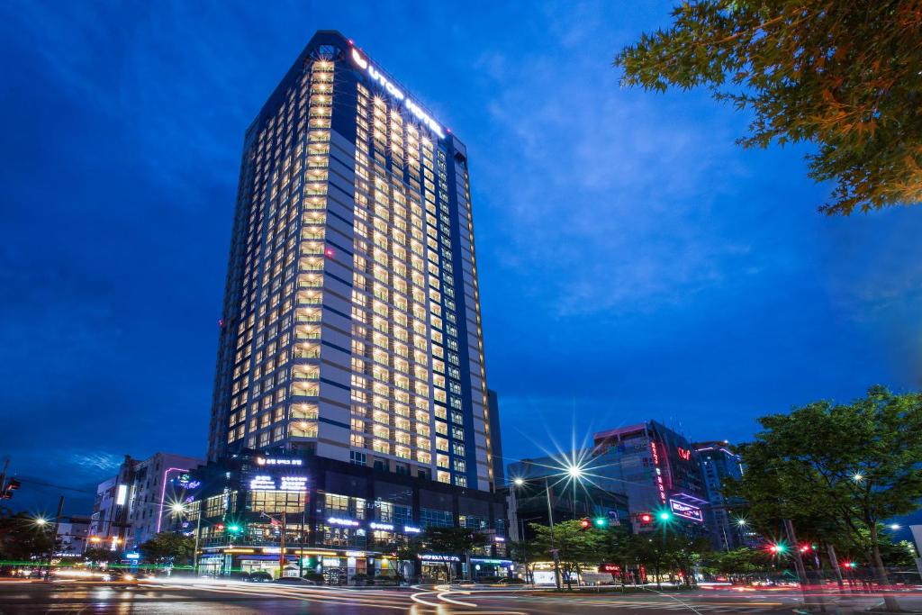 a tall building with lights on it at night at Utop Boutique Hotel&Residence in Gwangju