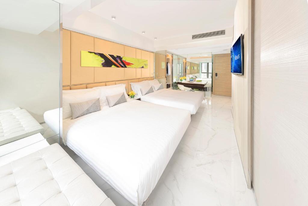 una camera d'albergo con due letti e una tv di iclub AMTD Sheung Wan Hotel a Hong Kong